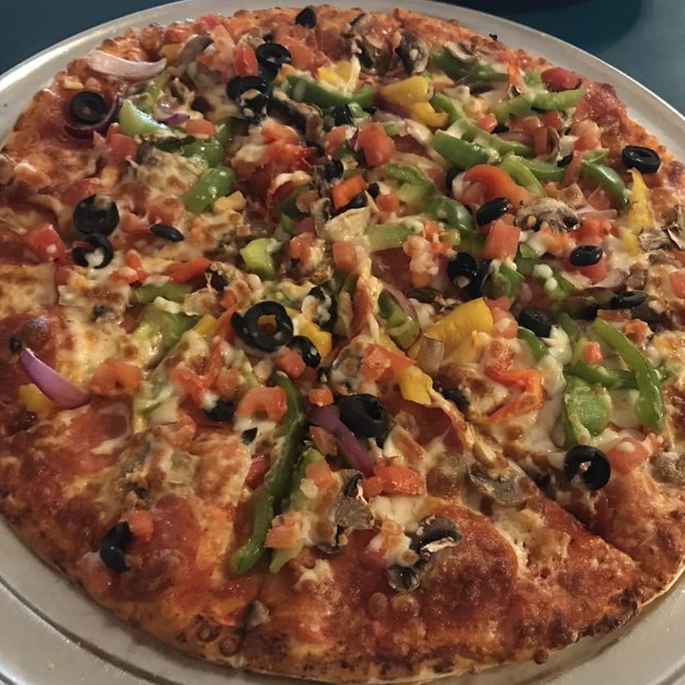 A whole pizza from Socorro's Restaurant, topped with pepperoni, olives, peppers, onions, and mushrooms.